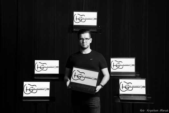 Dyrektor Krystian Marut prezentujący 6 laptopów uzyskanych z projektu Sieć na kulturę w podregionie tarnobrzeskim